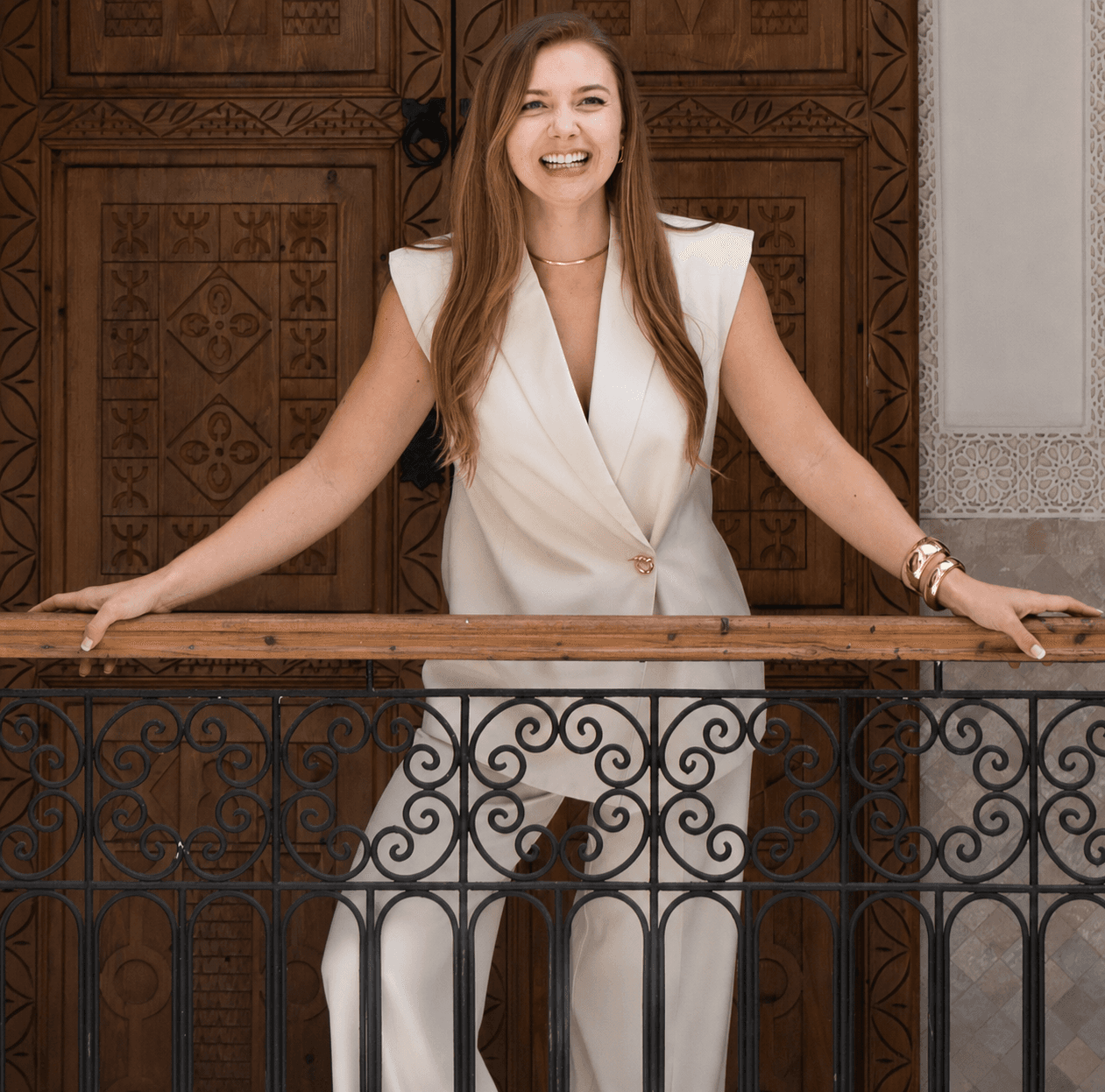 Madison laughing on a wrought-iron balcony