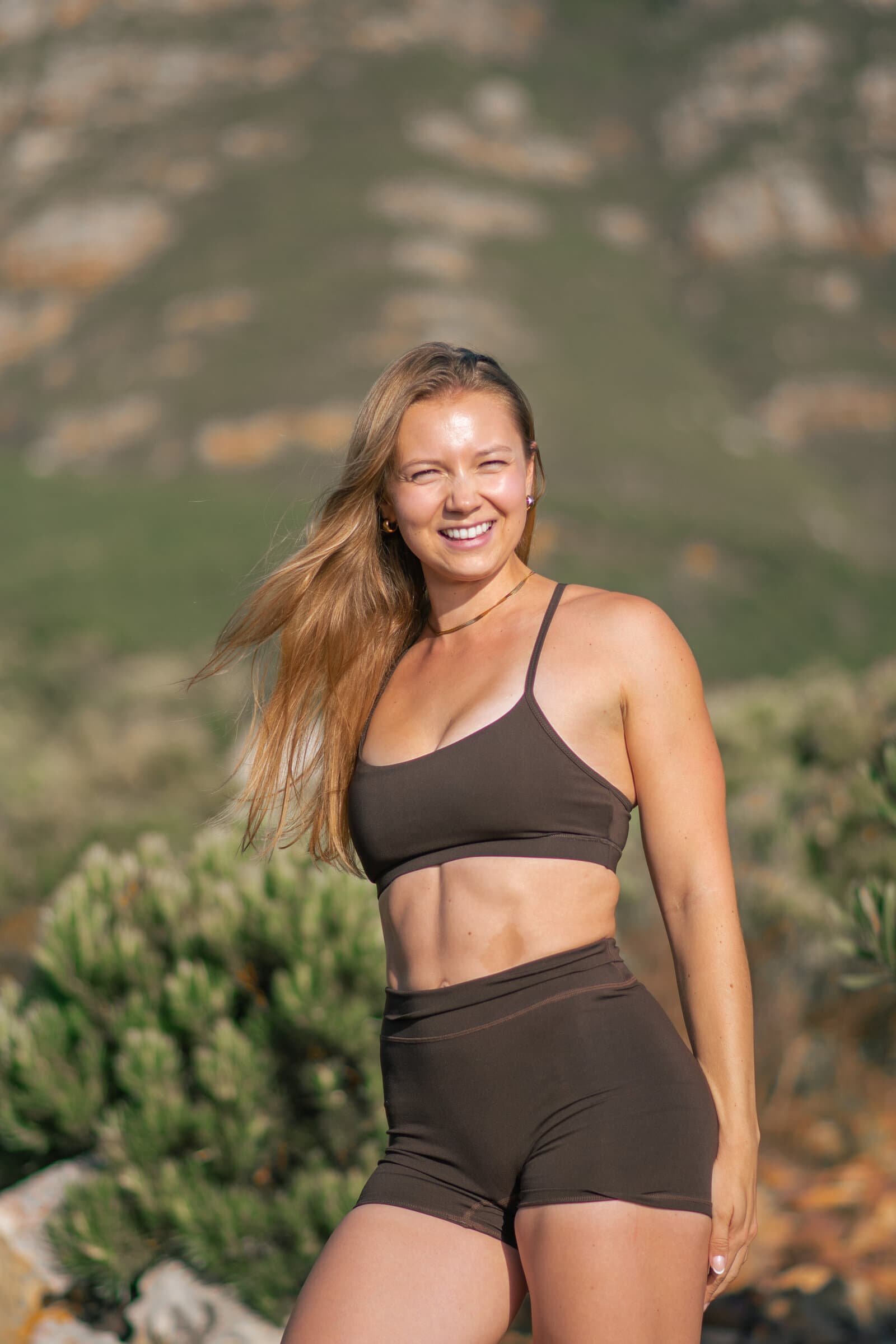 Madison outdoors in the mountains, arms raised